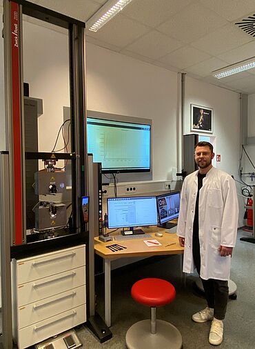 polymerphysIK Mitarbeiter vor ZwickRoell Materialprüfmaschine mit testXpert Analytics