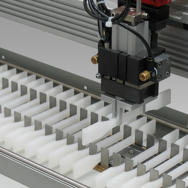 The robotic testing system removes a specimen from the magazine