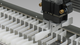 The specimen gripper of the automated testing machine removes the specimen from the magazine