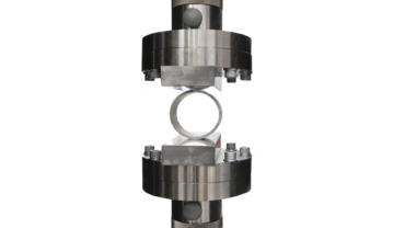 Beim Ringfaltversuch nach ISO 8492 wird ein Rohrring mithilfe von Druckplatten zusammengedrückt.