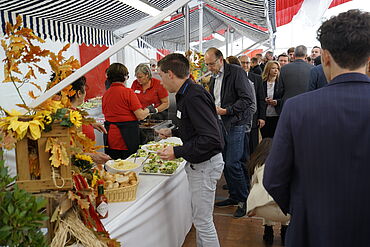 Visitantes no balcão de alimentação na tenda