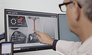 Ein Anwender bedient die Prüfsoftware über einen Touchmonitor