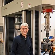 El profesor Geir I. Vestøl de la NMBU delante de la máquina de ensayos para madera