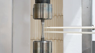 Zeitstandversuch / Kriechversuch an einer Metallprobe bis +1,200°C in einem Hochtemperatur-Ofen und kontaktierendem Extensometer für die Dehnungsmessung
