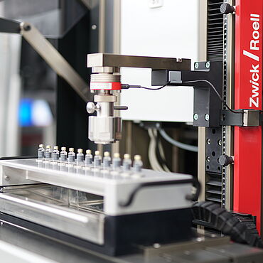 zwickiLine und XY-Kreuztisch mit motorischer Steuerung zur sequentiellen Prüfung der Dichtungs-Vorspannkraft (Residual Seal Force) an Karpulen/Arzneifläschchen