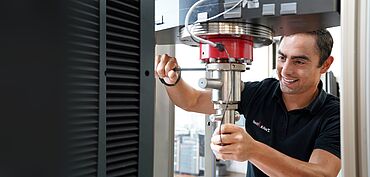 Serviceingenieur von ZwickRoell bei der Kalibrierung von Materialprüfmaschinen