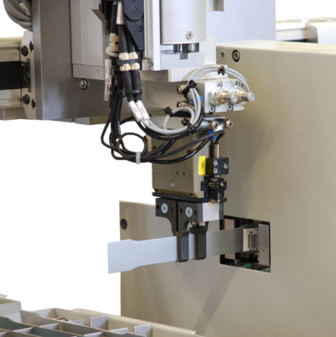 The robot holds the specimen in the cross-section measuring device