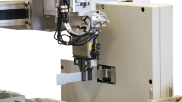 The robot holds the specimen in the cross-section measuring device