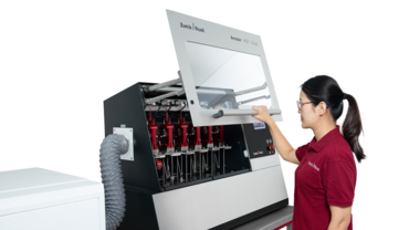 Amsler Allround 6-300 heat deflection tester met gebruiker en geopende veiligheidsdeur